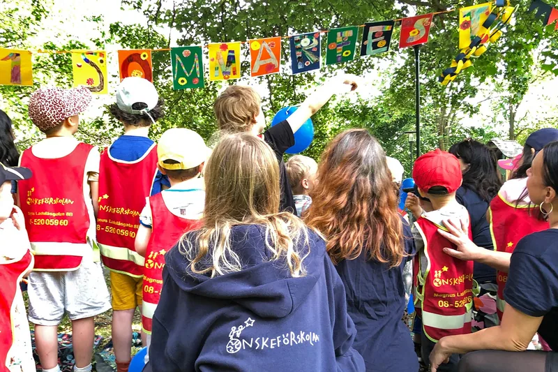 Barn och personal på förskola utomhus.