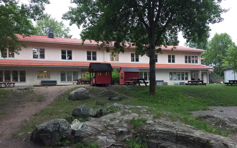 Förskolan med den fina lite bergiga naturgården i förgrunden.