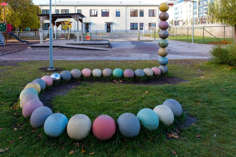 Gård med lekhus, sandlåda, klätterställning med mera samt hus i bakgrunden.