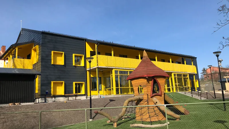 Förskolan Humlan exteriört. En gul och svart fristående fastighet i två våningar.