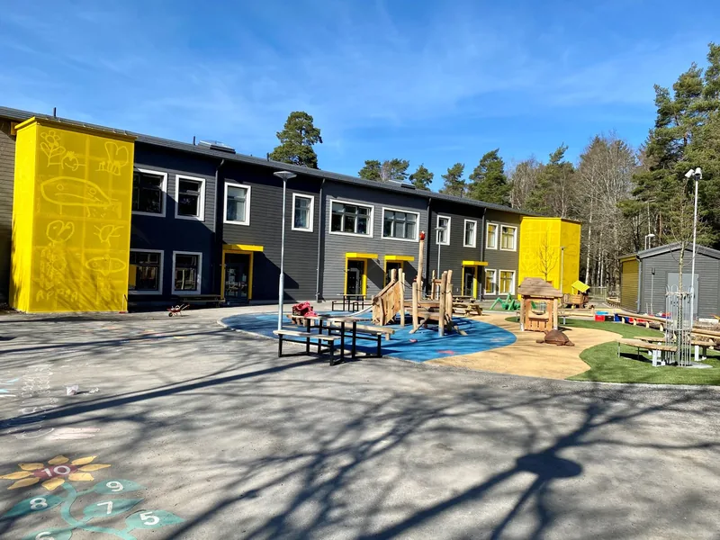 En stor tvåvåningsbyggnad med en solig gård.