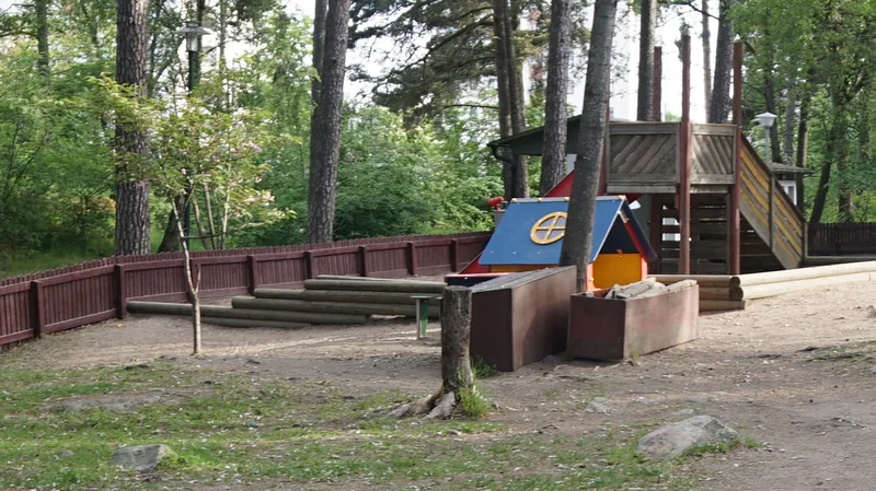 Förskolegård med hus, klätterborg och rutschkana.