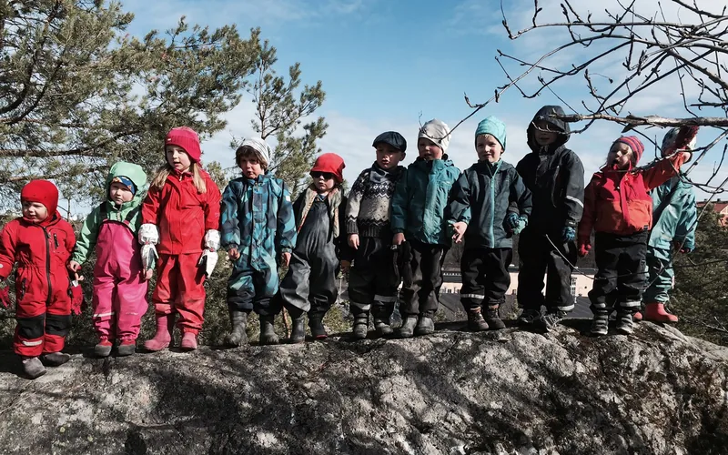 Barn i rad på ett litet berg