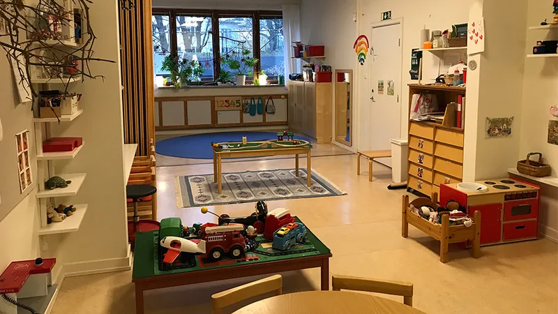 Förskolemiljö med leksaker och låga möbler.
