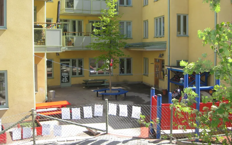 Förskolans utemiljö med lekytor, bord och klätterställning.