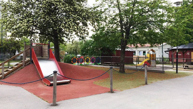 Förskolans gård, rutschkana och klätterhus.